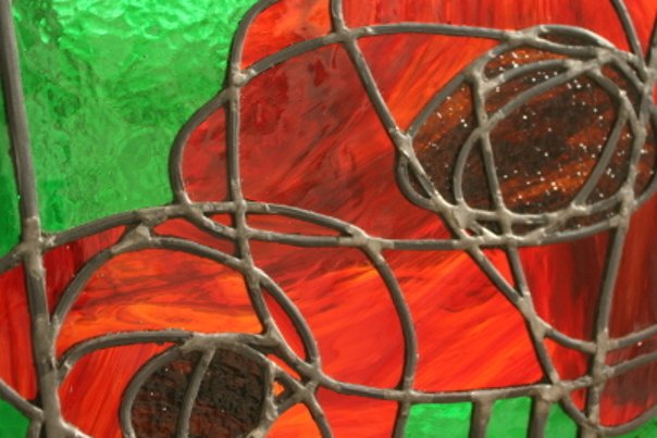 Détail d’un vitrail rouge et vert présenté par La Procure